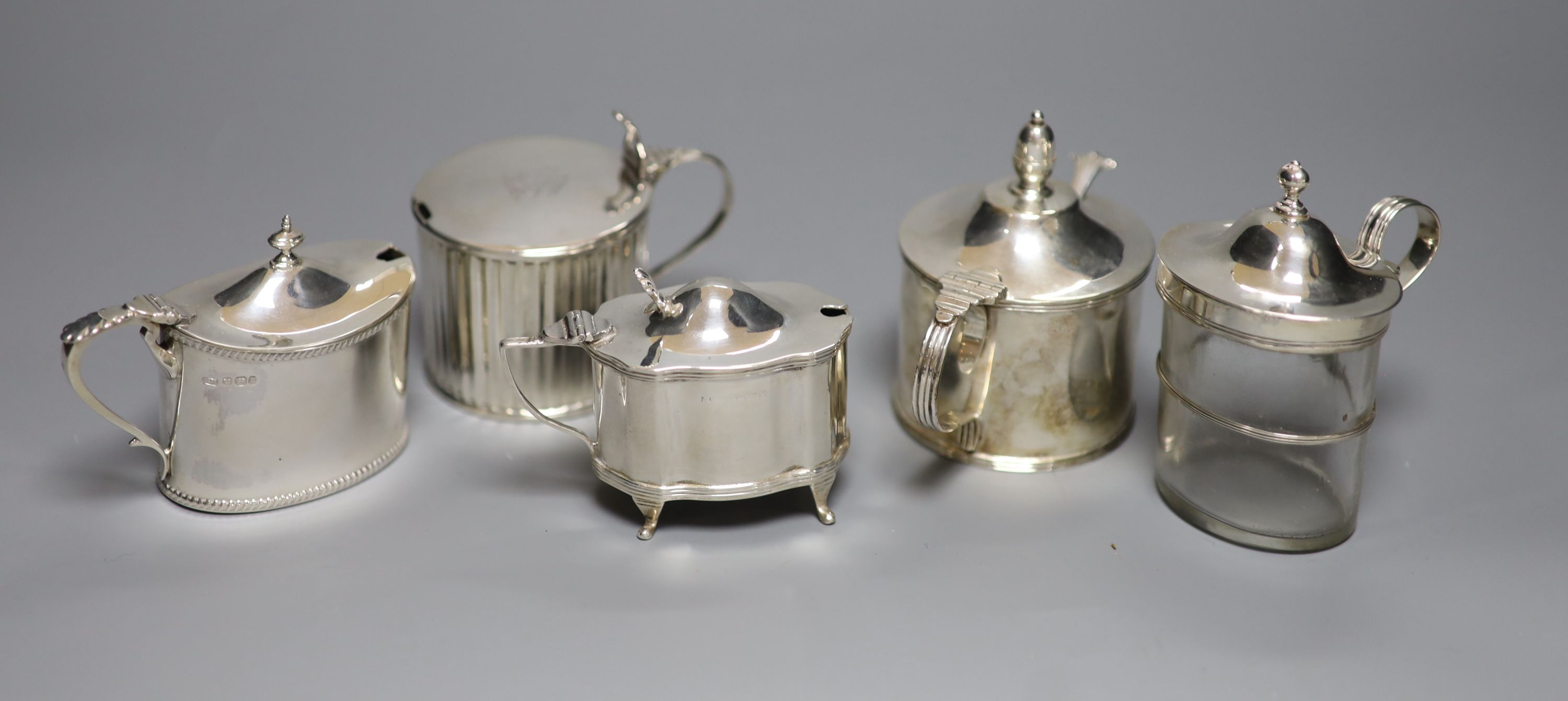 Five mustard pots, various, including a large cylindrical mustard by Mappin & Webb, 1934 Jubilee mark, a similar reeded George III mustard